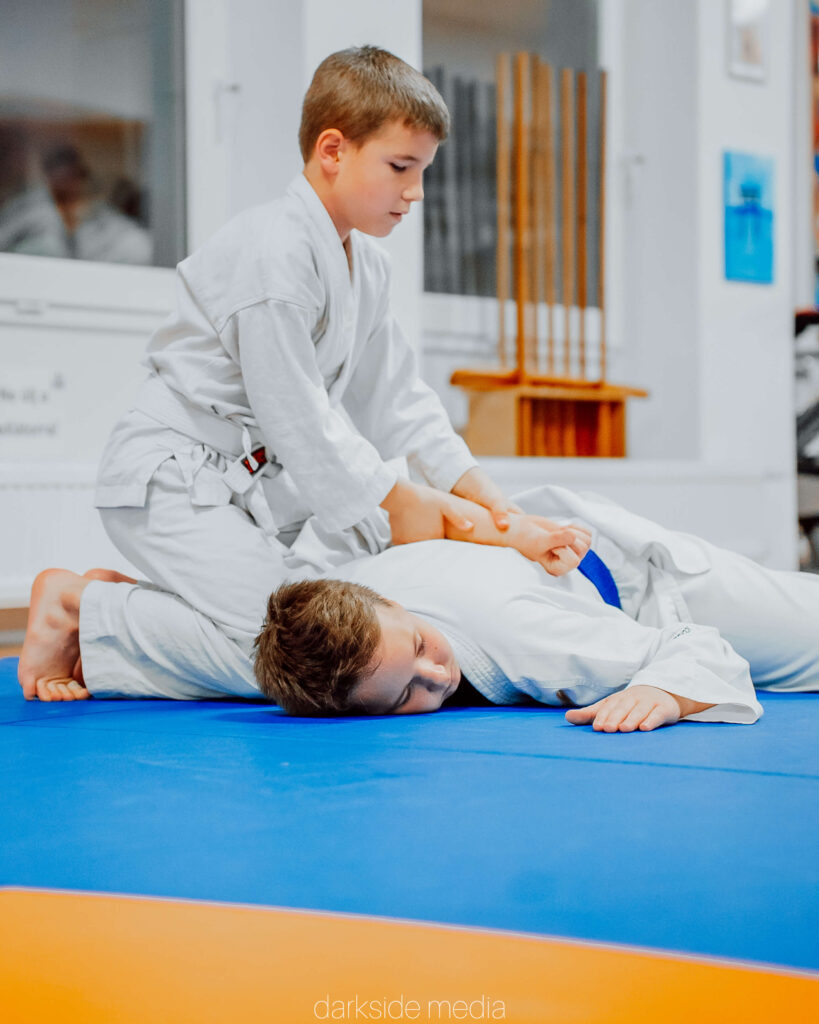 Fiatal aikido gyakorló leszorítást hajt végre